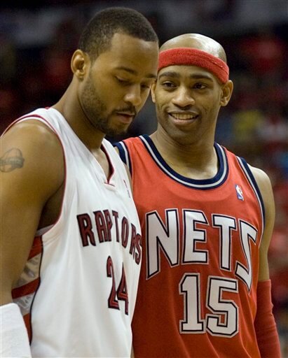 Morris Peterson looking away as Vince Carter chats him up. (AP)