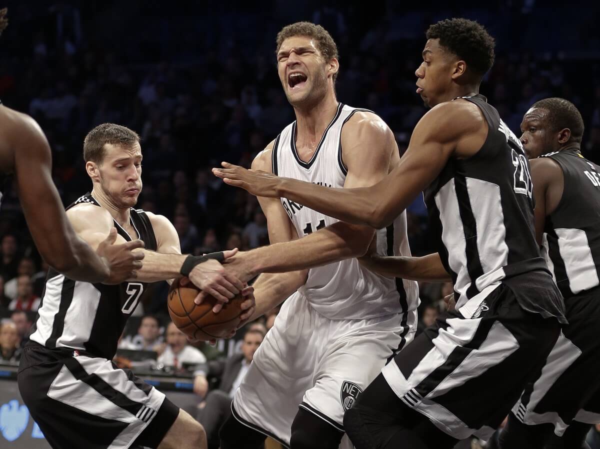 Miami Heat's Goran Dragic (7) and Hassan Whiteside (21) defend Brooklyn Nets' Brook Lopez (11) during the second half of an NBA basketball game Wednesday, Dec. 16, 2015, in New York. The Heat won 104-98. (AP Photo/Frank Franklin II)