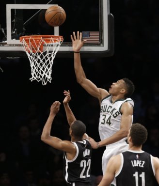 Milwaukee Bucks' Giannis Antetokounmpo, top, puts a shot up over Brooklyn Nets defenders during the second half of the NBA basketball game at the Barclays Center, Sunday, March 13, 2016 in New York. The Bucks defeated the Nets 109-100. (AP Photo/Seth Wenig)
