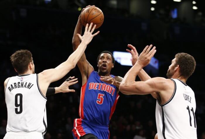 Andrea Bargnani (9) and Brook Lopez (11) defend Detroit Pistons guard Kentavious Caldwell-Pope (5) as Pope goes up for a layup in the first half. (AP Photo/Kathy Willens)