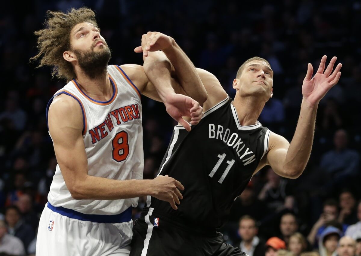 New York Knicks' Robin Lopez (8) and Brooklyn Nets' Brook Lopez (11) fight for position during the first half of an NBA basketball game Wednesday, Jan. 13, 2016, in New York. (AP Photo/Frank Franklin II)