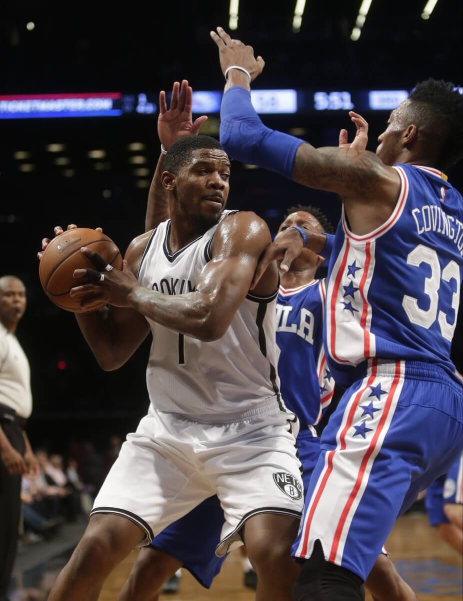 Joe Johnson (7) looks to pass away from Philadelphia 76ers' Robert Covington (33) and Isaiah Canaan during the second half of an NBA basketball game Thursday, Dec. 10, 2015, in New York. The Nets won 100-91. (AP Photo/Frank Franklin II)