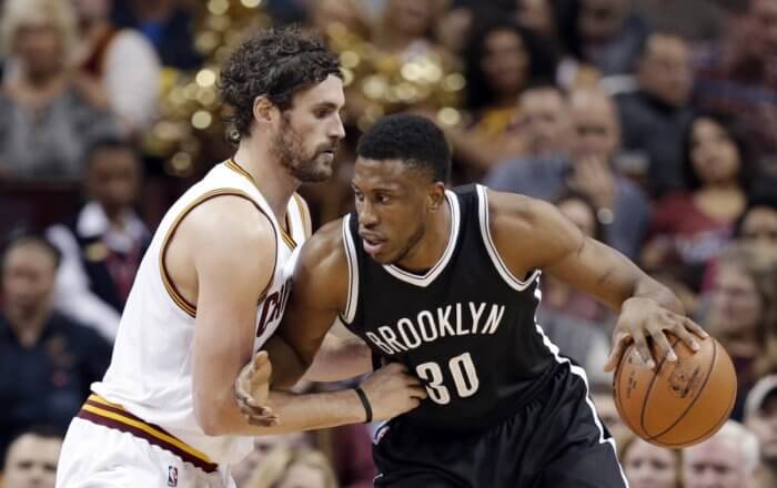 Thaddeus Young drives past Cleveland Cavaliers' Kevin Love in the first half. (AP Photo/Tony Dejak)
