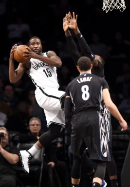 Brooklyn Nets guard Donald Sloan (15) leaps to pass around Minnesota Timberwolves forward Tayshaun Prince and guard Zach LaVine (8) during the first half of an NBA basketball game on Sunday, Dec. 20, 2015, in New York. (AP Photo/Kathy Kmonicek)