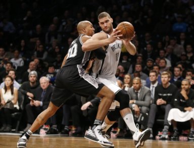 San Antonio Spurs forward David West (30) defends Brooklyn Nets center Brook Lopez (11) as he drives toward the basket in the first half of an NBA basketball game, Monday, Jan. 11, 2016, in New York. (AP Photo/Kathy Willens)
