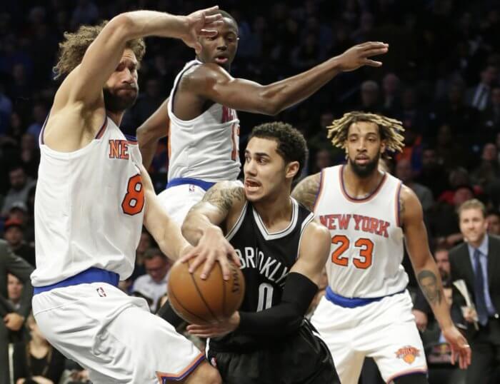 Brooklyn Nets' Shane Larkin (0) passes away from New York Knicks' Derrick Williams (23), Jerian Grant and Robin Lopez (8) during the second half of an NBA basketball game Wednesday, Jan. 13, 2016, in New York. The Nets won 110-104. (AP Photo/Frank Franklin II)