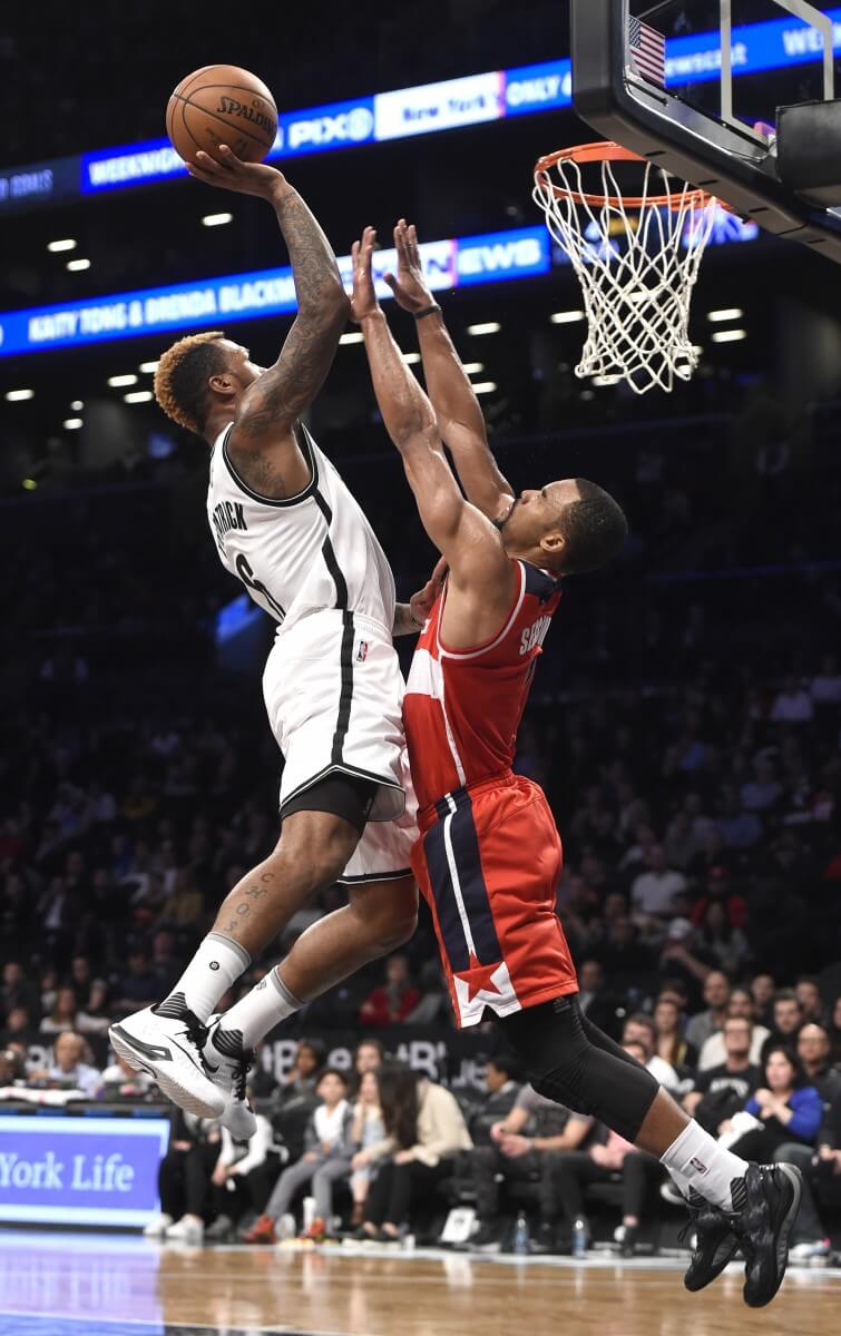 Brooklyn Nets guard Sean Kilpatrick, left, drives to the basket against Washington Wizards guard Ramon Sessions, right, during the second half of an NBA basketball game on Monday, April 11, 2016, in New York. The Wizards won 120-111. (AP Photo/Kathy Kmonicek)