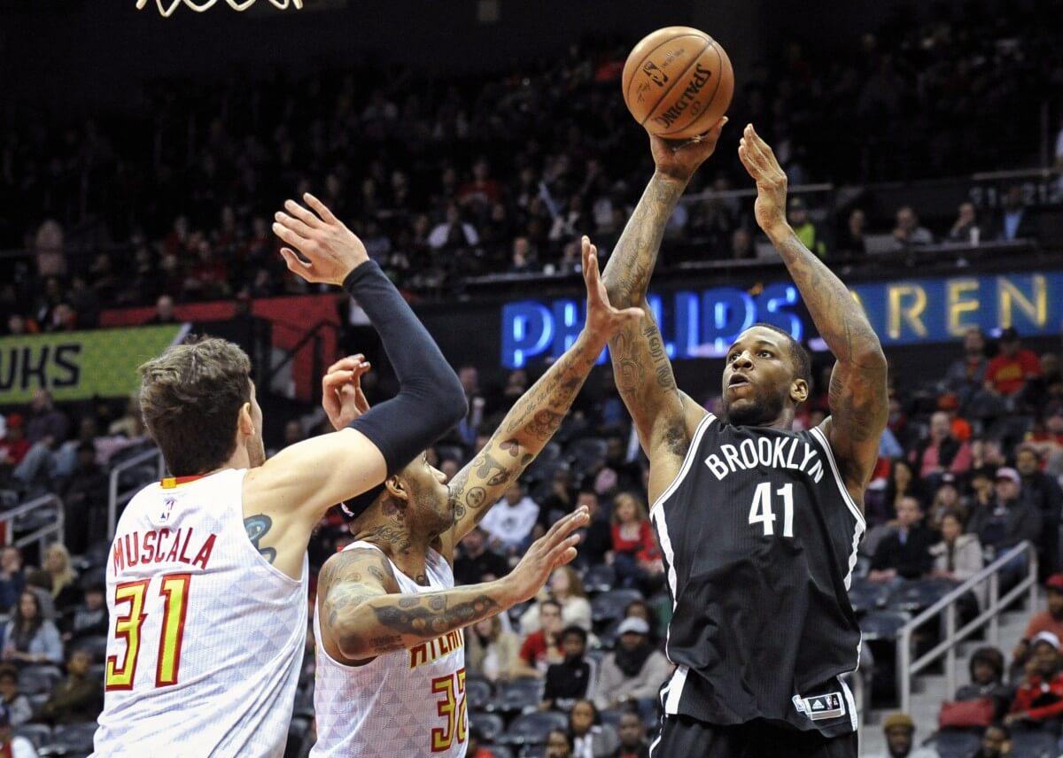 Brooklyn Nets forward Thomas Robinson (41) shoots a jump shot Atlanta Hawks forward Mike Muscala (31), and forward Mike Scott defend during the second half of an NBA basketball game, Saturday, Jan. 16, 2016, in Atlanta. Atlanta won 114-86. (AP Photo/John Amis)