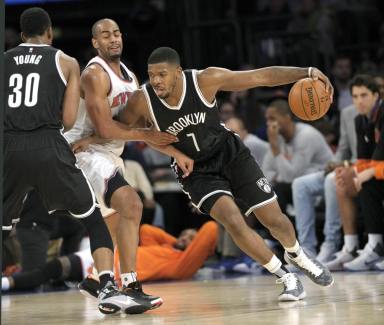 New York Knicks guard Arron Afflalo runs into a pick set by Thaddeus Young (30) as Afflalo guards Nets guard Joe Johnson (7) during the third quarter. The Knicks defeat the Nets 108-91. (AP Photo/Bill Kostroun)