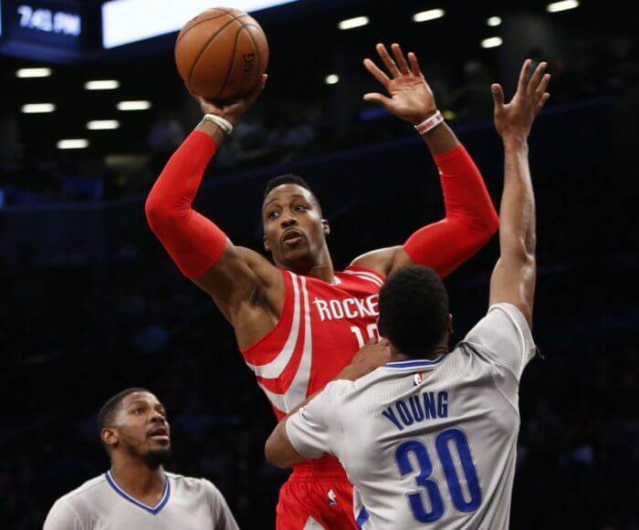 Houston Rockets center Dwight Howard, center, passes as Brooklyn Nets forward Thaddeus Young (30) defends in the first half. (AP Photo/Kathy Willens)