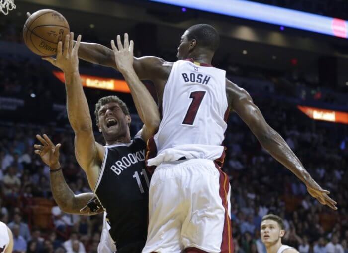 Brooklyn Nets' Brook Lopez (11) is fouled by Miami Heat's Chris Bosh (1) during the first half of an NBA basketball game, Monday, Dec. 28, 2015, in Miami. (AP Photo/Lynne Sladky)